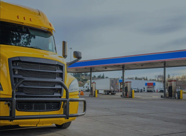 A freight truck parked at a fuel station